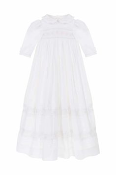 A future family heirloom, this traditional Christening or ceremony gown is the most exquisite gown in the Annafie catalogue yet! Truly fit for a little princess or prince, it features delicate hand smocking and embroidery both across the chest and on the skirt. The ruffled peter pan collar and elegant sleeves create a romantic silhouette which is completed by the traditional long skirt that will drape over your arms as you carry your baby. Made from 100% fine, breathable and extremely luxurious Elegant Fitted Smocked Dress With Lace Trim, Elegant Smocked Dress With Smocked Cuffs For Baptism, Fitted Wedding Dress With Smocked Cuffs, Elegant Baptism Dress With Smocked Back, Elegant Smocked Ruffle Dress For Baptism, Elegant Dress With Smocked Back For Baptism, Elegant Baptism Dress With Smocked Bodice, Elegant Fitted Baptism Dress With Smocked Bodice, Elegant Smocked Dresses For Baptism