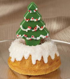 a small christmas tree on top of a doughnut covered in icing and sprinkles