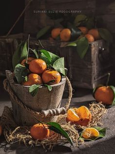 a wooden bucket filled with lots of oranges