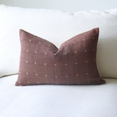 a brown pillow sitting on top of a white couch