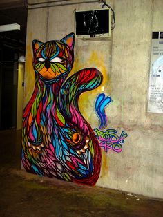 a colorful cat painted on the side of a building