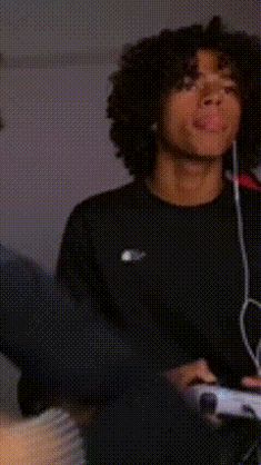 two young men sitting next to each other holding nintendo wii controllers