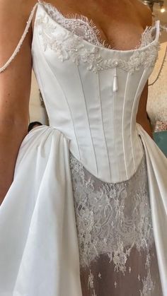 a woman in a white wedding dress is posing for the camera