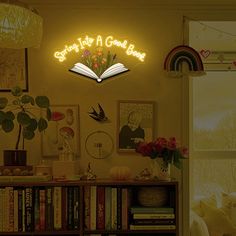 there is a neon sign above the bookshelf that says, start into a good book