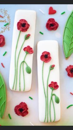 two cookies decorated with red flowers and green leaves