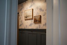 an open door leading to a room with wallpaper and pictures on the walls in it