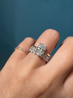 a woman's hand with two engagement rings on it