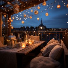 a table with candles on it and some lights hanging from the ceiling over it in front of a cityscape