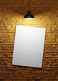 a brick wall with a white sheet of paper hanging from it's side next to a black lamp