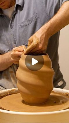 a man is making a vase out of clay on a potter's wheel with his hands