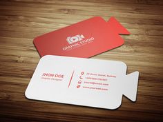 two business cards sitting on top of a wooden table next to an envelope with the logo for graphic studio