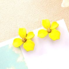 two yellow flowers sitting on top of a piece of paper