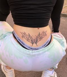 a woman with a butterfly tattoo on her stomach