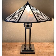 a lamp that is sitting on top of a wooden table with a sky in the background