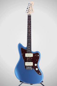 an electric guitar sitting on top of a tripod with a blue body and neck