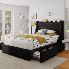 a bedroom with white walls and wooden floors has a black headboard on the bed