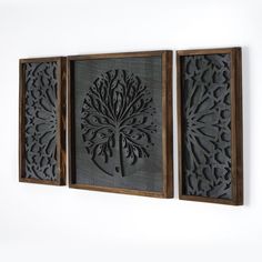 three metal artwork pieces hanging on the wall