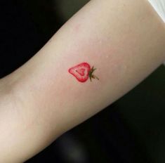 a small strawberry tattoo on the arm with a rose in it's center piece