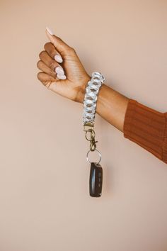 a person's hand holding a key chain with a car charm attached to it