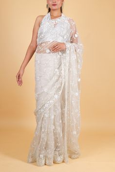 Indulge in luxury and sophistication with our stunning net designer saree. Adorned with delicate thread embroidery and sparkling sequin work, this cream-colored saree exudes elegance and charm. Perfect for special occasions, it will make you stand out in the most tasteful way. Elevate your wardrobe today with this exquisite piece. Net designer saree with thread embroidery and sequin work - cream color Saree comes with a blouse piece. Fall and pico done. Fully stitched blouse shown in pictures is optional and can be purchased seperately from our blouses and croptops section. For saree video please connect with us on whatsapp @469-937-0606 Ready to be shipped in USA from San Diego, California. All pictures are original pictures. Colors may slightly vary due to pic resolution. Net Saree With Zari Work, Festive Net Saree With Cutdana, Party Saree With Chikankari Embroidery In Tissue Silk, Party Saree With Chikankari Embroidery On Tissue Silk, Party Tissue Silk Saree With Chikankari Embroidery, Off White Organza Dupatta With Zari Work, Party Wear Saree In Tissue Silk With Resham Embroidery, Semi-stitched Lace Saree With Sheer Dupatta, Party Wear Saree With Intricate Embroidery For Festive Occasions