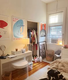 a bedroom with a bed, desk and various pictures on the wall above it in front of a window