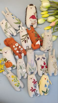 a bunch of stuffed animals sitting on top of a table next to tulips