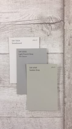 some white and gray paint samples on a wooden surface