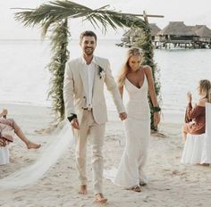 a newly married couple walking down the beach