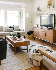 a living room filled with furniture and a flat screen tv on top of a wooden stand