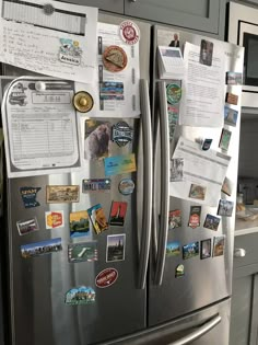 a stainless steel refrigerator covered in magnets and papers