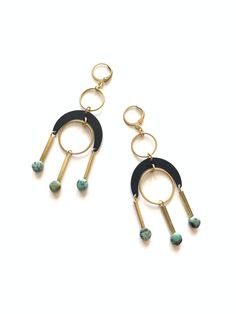 two hoop earrings with beads and black, gold and turquoise beads are hanging from them