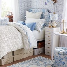 a bedroom with blue and white decor on the walls, bed linens, and pillows