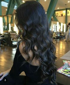 a woman with long black hair sitting down