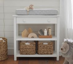 a white shelf with baskets and toys on it