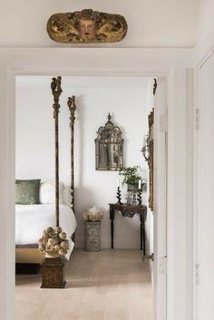 a bedroom with white walls and flooring has an ornate gold frame on the ceiling