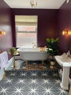 a bathroom with purple walls and white fixtures