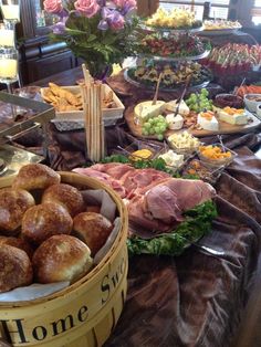 a table filled with breads, meats and other food on it's sides