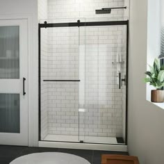 a bathroom with a white rug and black trimmings on the floor, along with a walk in shower