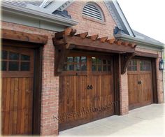 two wooden garage doors are shown in front of a brick building