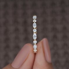 a close up of a person's hand holding a ring with three diamonds on it