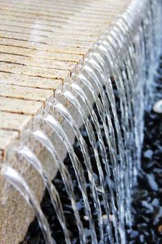 the water is running down the side of the fountain