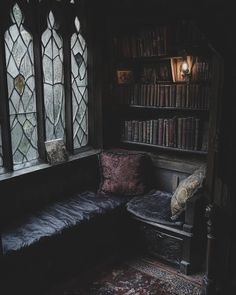 an old room with stained glass windows and a couch in front of the bookshelf