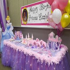 there is a table with princess decorations on it and balloons in the air behind it