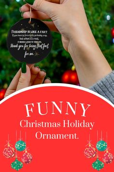 a person holding up a christmas ornament with the words funny, christmas holiday ornament