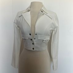 Nice Short Crop Jacket In White, Logo Snaps On The Front And Sleeves, Zipped Details At The Neck, Lined. Size 6 But Runs Smaller: Bust 34” Waist 28” Length 17” Sleeves 22 1/2”. Jacket Is New With Tags, 80 % Polyester 17% Rayon 3% Elastase. New With Tags Please Check The Measurements White Cropped Formal Outerwear, Formal White Cropped Outerwear, White Cropped Outerwear For Formal Occasions, White Cropped Jacket For Formal Fall Occasions, White Cropped Blazer For Office, Long Sleeve Cropped Jacket With Zipper For Work, Fitted Collared Cropped Jacket With Buttons, Tailored Cropped White Outerwear, Fitted Cropped Jacket With Button Closure And Long Sleeves