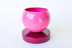 a pink vase sitting on top of a purple stand