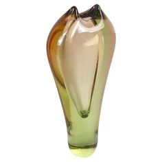 a green and yellow glass vase sitting on top of a table