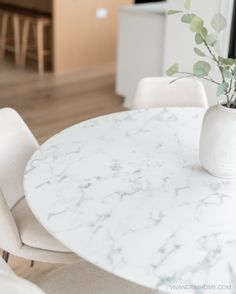 a white marble table and chairs in a room