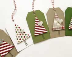 small tags with christmas trees on them are hanging from twine string and decorated with red, white and green striped paper