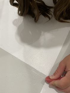 a person with their hand on the edge of a piece of paper